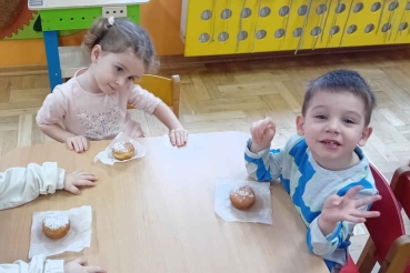Chłopiec z dziewczynką jedzą pączki
