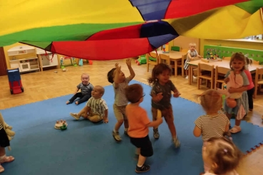 Dzieci pod kolorowym parasolem