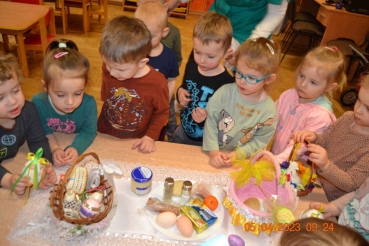 Dzieci układają pożywienie do koszyczka wielkanocnego
